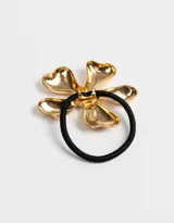 Gomita de pelo elástica negra con aplique de flor dorada de metal.