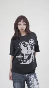 Remera negra de algodón con estampa frontal de una figura femenina con texto.