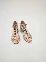 Sandalias de charol con estampado floral, taco cuadrado y correa fina en el tobillo.