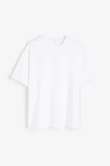 Remera blanca de algodón pesado, corte holgado, con cuello redondo ribeteado, hombros caídos y bajo recto.