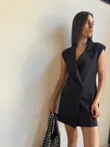 Chaleco corto negro con solapas, doble botonadura y corte sastrero. Sin mangas.