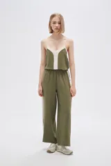 Pantalón ancho de poliéster color verde oliva con cintura elástica y una franja vertical blanca a cada lado.