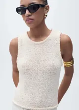 Top tejido de crochet color crema, sin mangas, con cuello redondo y tirantes anchos.