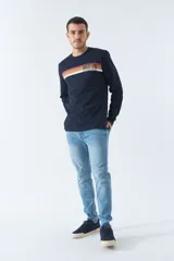 Pantalón de jean gris oscuro, corte carrot, tiro medio, con logo bordado y presillas para cinturón.