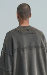 Buzo cuello redondo color gris oscuro con efecto gastado, costuras expuestas, calce oversize y roturas.