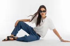 Pantalón de denim color azul índigo, con tiro medio-alto y tablas en la cintura, corte recto y bolsillos laterales.