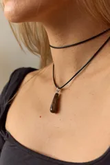 Gargantilla doble con choker de cuero negro y collar con dije de piedra natural marrón en forma de gota con engarce de acero quirúrgico hipoalergénico y tiento negro.