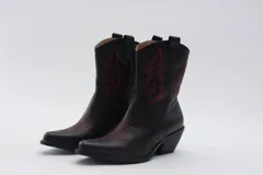 Bota texana de cuero negro con bordados en el lateral y taco bajo.