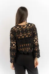 Blusa beige de hilo calado con mangas largas y cuello redondo.