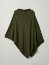 Poncho tejido de punto grueso, color mostaza/mostaza oscuro, con cuello redondo y caída amplia.