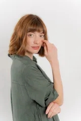 Vestido camisero midi color verde militar, de lino 100%, con silueta oversize, cuello camisero, mangas 3/4 con botón para ajustar y aberturas laterales.