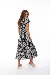 Vestido midi negro con estampado floral blanco, escote en V, mangas cortas y lazo en la cintura.