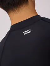 Remera de surf Rusty de manga larga, color negro con logo blanco en el pecho.