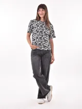 Remera de manga corta con estampado abstracto en tonos beige, negro y blanco.