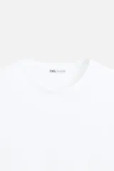 Camiseta slim fit de cuello redondo y manga corta, confeccionada en tejido de algodón con elasticidad.