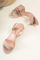 Sandalias con tacón bajo de color rosado, con tiras cruzadas en la parte delantera.