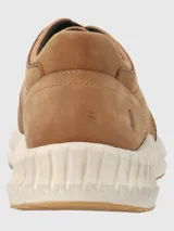 Sneakers marrones de cuero con cordones y suela blanca texturizada.