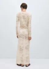 Vestido largo de tejido de punto fino color crudo, con cuello redondo, diseño entallado y mangas largas. Incluye cinturón de cadena dorada.