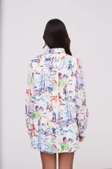 Camisa blanca con estampado multicolor de dibujos urbanos, de corte holgado y manga larga.