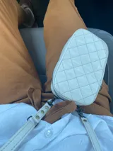 Bandolera pequeña color crudo con diseño acolchado en forma de rombos. Incluye correa larga regulable y tarjetero interno.