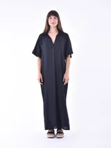 Vestido largo negro con cuello camisero, mangas cortas y corte holgado.