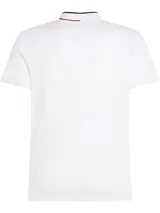 Chomba blanca de corte slim con cuello mao, tapeta de tres botones y logo de Tommy Hilfiger bordado en el pecho. El cuello presenta una banda con los colores característicos de la marca: azul marino, blanco y rojo.