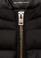 Chaleco negro acolchado con cierre frontal y cuello redondo.