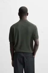 Polo de punto color verde oscuro, tejido en hilatura de algodón, de corte regular fit, con cuello solapa y cierre frontal de botonadura.