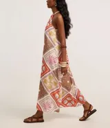 Vestido midi evasê sin mangas, confeccionado en viscolino con cuello halter y estampado tropical con cuadros e ilustraciones. El tejido contiene viscosa certificada.