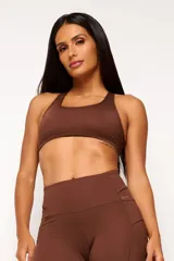 Top deportivo negro con diseño nadador, entrada para almohadillas removibles, bolsillo trasero y detalle reflectivo.