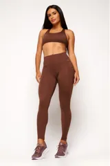 Top deportivo negro con diseño nadador, entrada para almohadillas removibles, bolsillo trasero y detalle reflectivo.