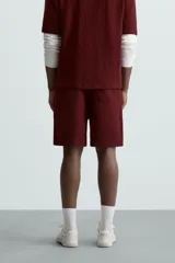 Bermuda negra de corte relaxed fit, con cintura elástica ajustable con cordón, bolsillos frontales y bolsillo trasero de parche.