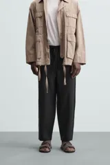 Pantalón negro de lino, corte recto y relaxed fit, con cintura elástica ajustable con cordón, bolsillos laterales y traseros.