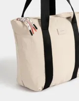 Bolso negro tipo shopper de tela deportiva con doble asa de hombro, cierre superior con tirador de cordón y goma, y etiqueta de goma con logo.