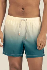 Short de baño con degradé de color beige a azul, con cintura elástica y cordón ajustable. Tiene protección UV50, logo de la marca, dos bolsillos laterales y uno trasero con cierre.