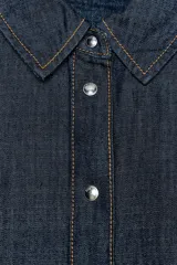 Camisa de denim azul oscuro, corte amplio, cuello solapa, manga larga y cierre frontal con botones a presión.