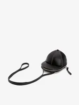 Bolso bandolera JW Anderson modelo Cap, con forma de gorra de béisbol, color negro con costuras blancas en contraste y cierre de cremallera. Incluye correa fina para colgar al hombro.