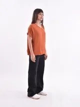 Blusa color verde oliva, de corte holgado, con escote en V y mangas cortas.