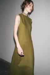 Vestido midi color verde oliva, confeccionado en lino 100%. De corte recto, cuello redondo y sin mangas.