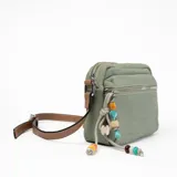 Bandolera verde de tela con correa marrón regulable y charms colgantes de cuentas de colores.