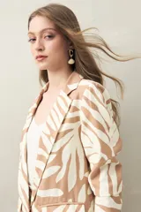 Blazer con estampado de hojas orgánicas en tonos beige y blanco, de corte recto, solapas clásicas y bolsillos con tapa.