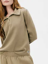 Camiseta tipo polo color beige, de manga larga y corte recto.