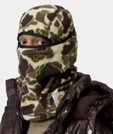 Balaclava de forro polar con estampado de camuflaje tipo 'Duck Camo' en tonos verde, marrón y beige. Presenta un borde elástico negro alrededor de la abertura para los ojos y una etiqueta tejida con el logo de Carhartt WIP en la parte inferior.