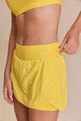 Pollera deportiva color verde lima, con short interno y bolsillo en la cintura.