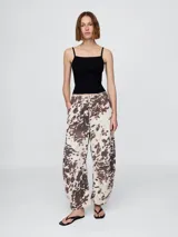 Pantalón jean tiro alto, corte amplio y estampado animal print de vaca en tonos marrones y blancos.