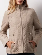 Campera capitoneada color beige, marca Gallery. Con cierre central, bolsillos delanteros con cierre, cinto de ajuste regulable en la cintura y forro interno a tono.