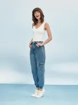 Pantalón de jean gris claro con efecto lavado, corte recto, tiro alto, bolsillos laterales y tobillos ajustados con elástico.