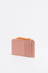 Monedero Bimba y Lola de piel color verde claro con cierre de cremallera y tirador de cordón naranja. Cuenta con logo metálico y tarjetero interior.
