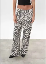 Pantalón de jean de tiro alto con estampado de cebra en tonos grises y blancos. Corte recto y holgado.