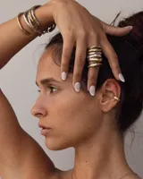 Aro earcuff plateado y dorado con diseño texturizado que simula lava.